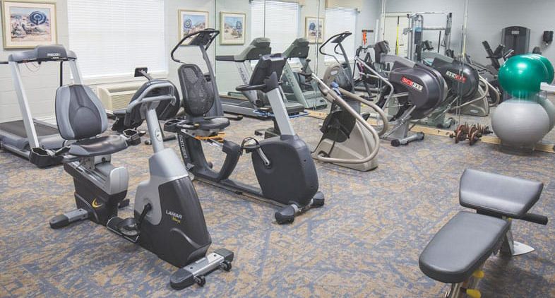 A gym with various exercise machines, including stationary bikes and treadmills.