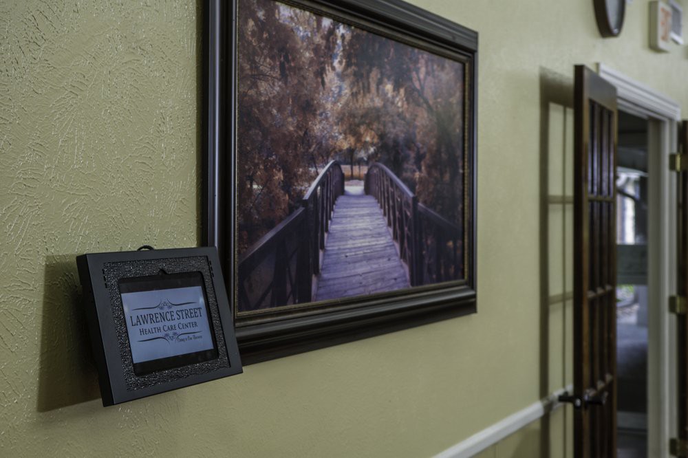 A framed painting of a serene boardwalk scene hangs on the wall of a hallway, accompanied by an informational plaque.