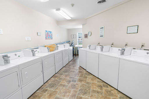 A bright and organized laundry room featuring multiple washing machines.