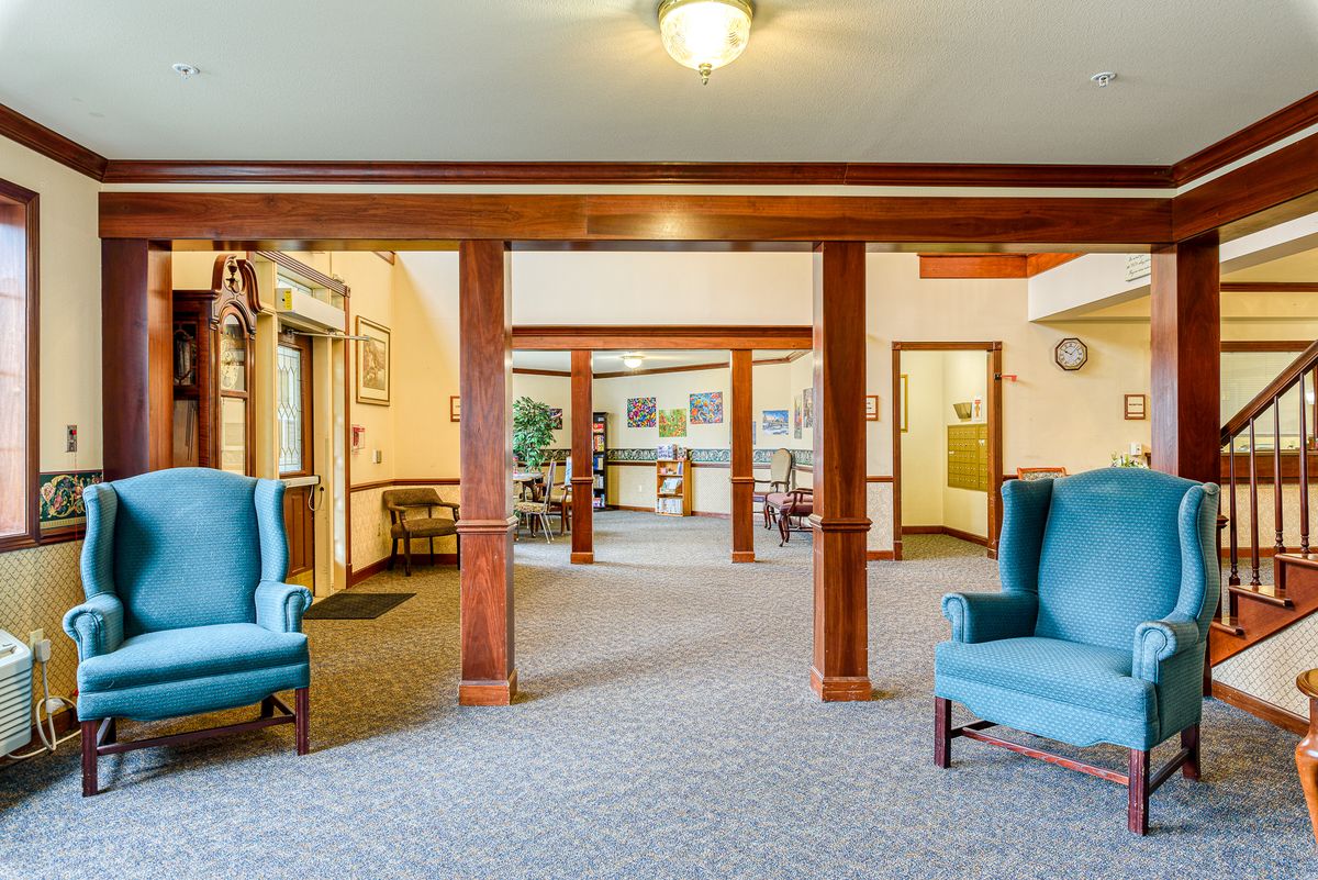 A spacious lobby with comfortable seating and wooden beams.