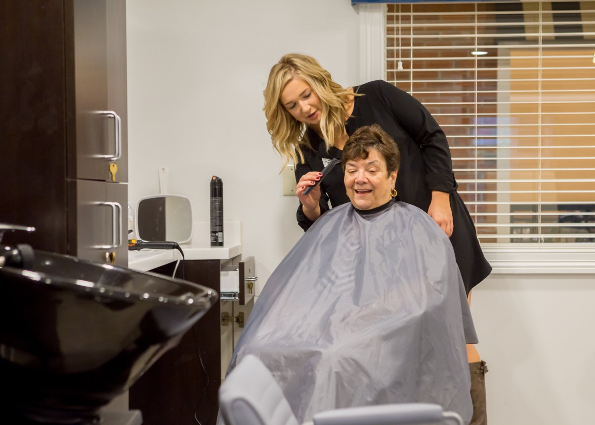 A hairstylist giving a haircut to a customer at a salon.