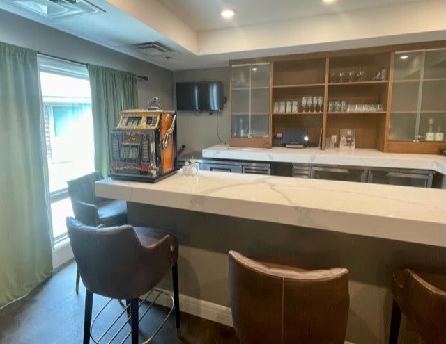 A modern bar interior with a sleek counter and comfortable stools.