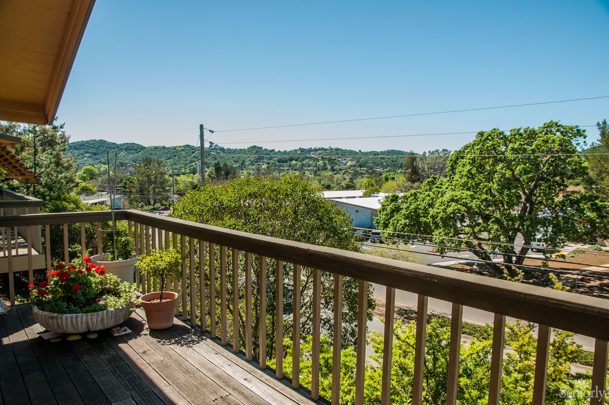 A scenic view from a balcony overlooking hills and greenery.