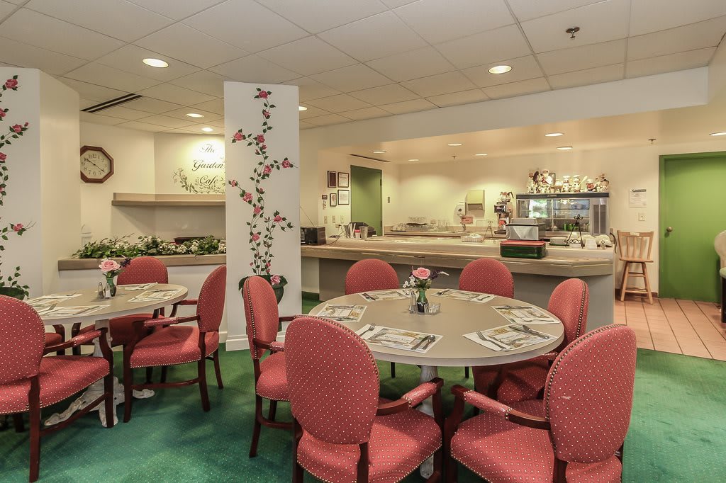 A cozy restaurant dining area with round tables and red chairs, offering an inviting atmosphere.