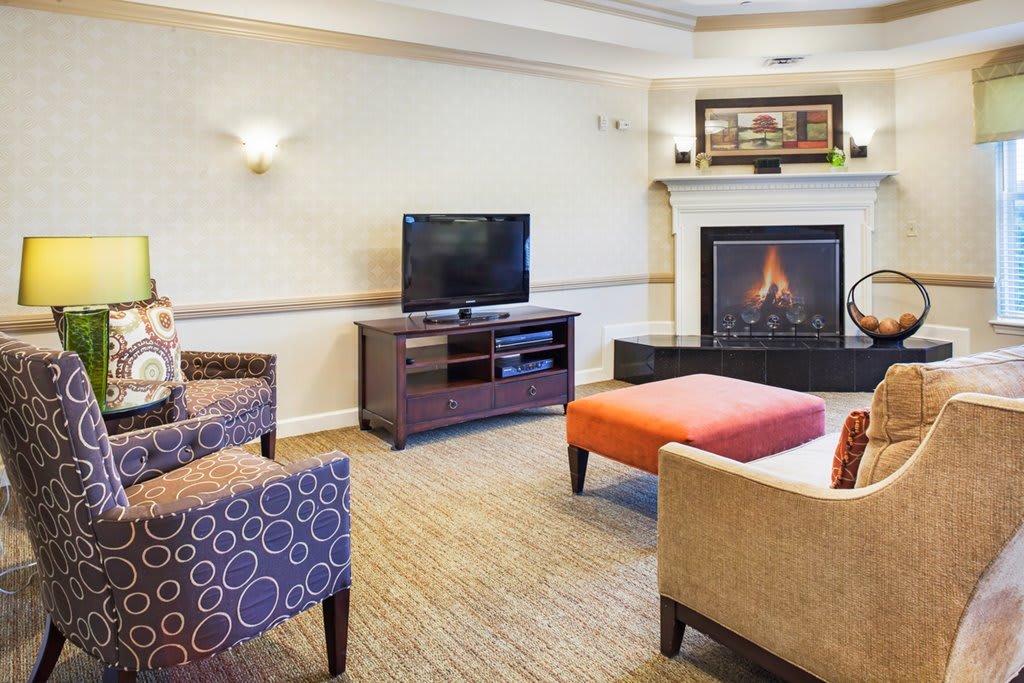 A cozy living room with a television, fireplace, and comfortable seating.