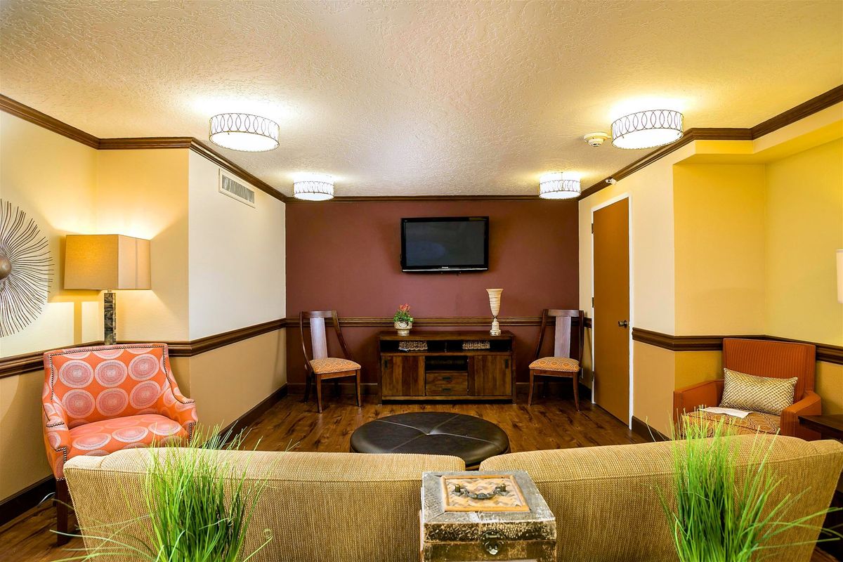 A modern waiting room with comfortable seating and a wall-mounted TV.