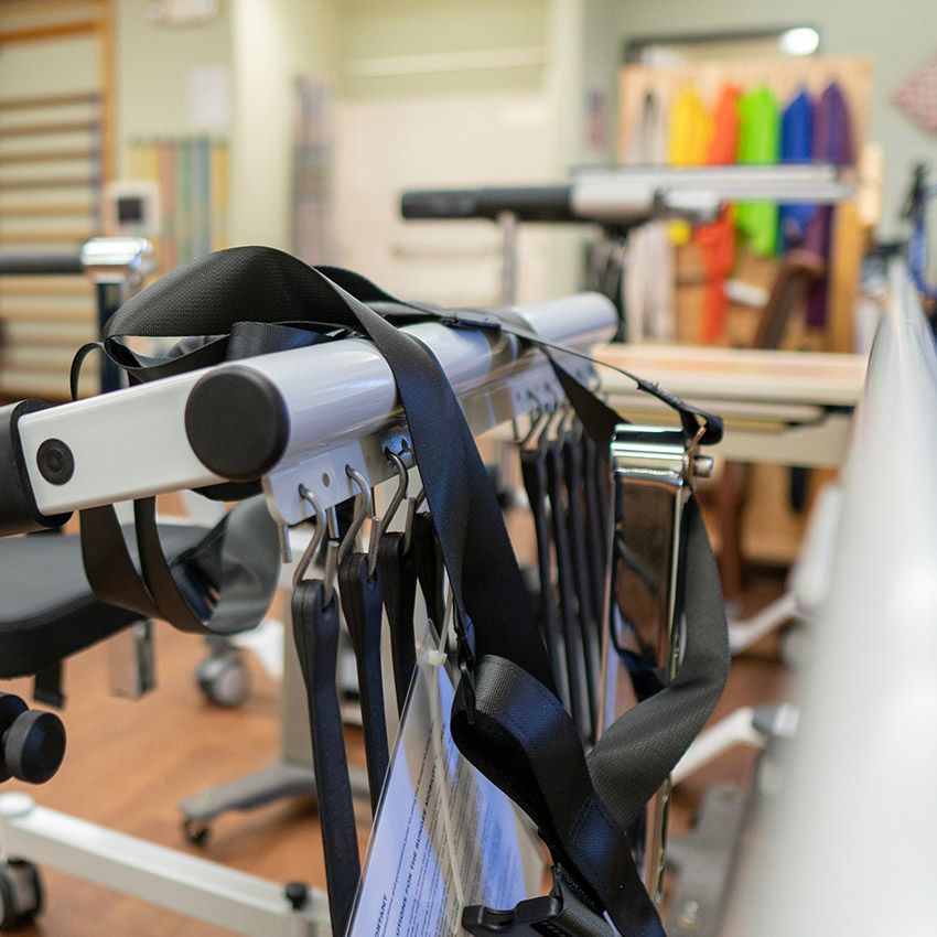 A physical therapy room featuring various exercise equipment and straps for rehabilitation exercises.