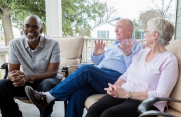 A group of people having a conversation on a patio.