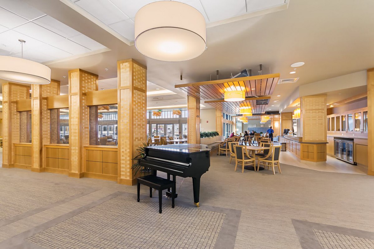 Modern lounge area with a grand piano and stylish wooden decor.