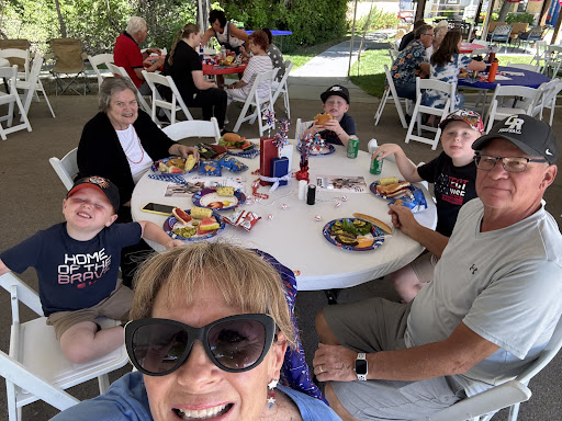A joyful family gathering enjoying a delicious barbecue meal in the sun.