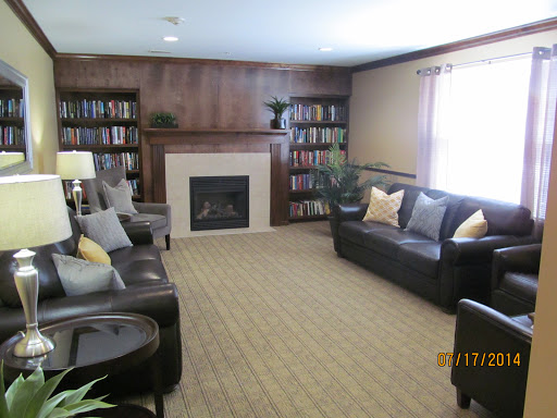 A cozy living room featuring a fireplace and bookshelves filled with books.
