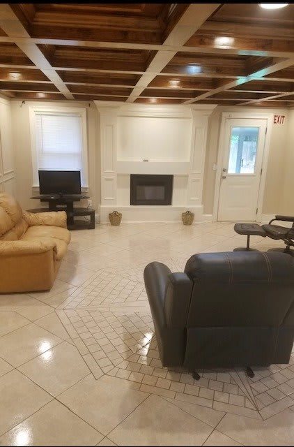 A cozy living room with a fireplace, television, and comfortable seating.