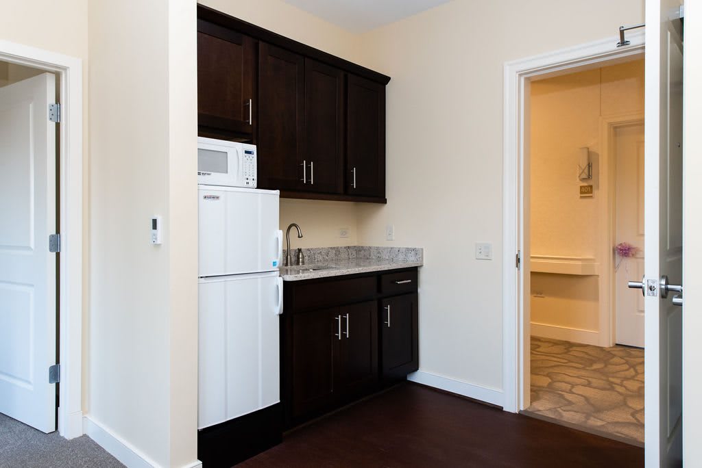 Small kitchen area with dark cabinets and basic appliances.
