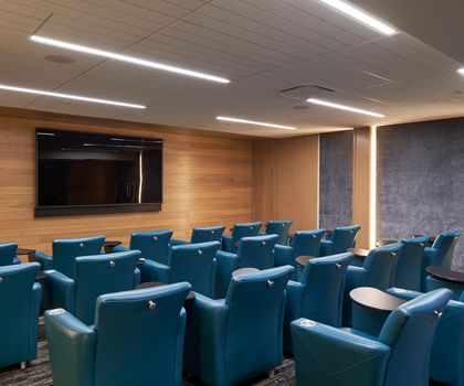 A modern conference room with theater-style seating and audiovisual equipment.