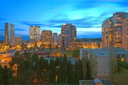A vibrant city skyline glowing with lights against a twilight sky.