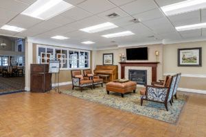 A cozy lobby with comfortable seating, a fireplace, and a television.