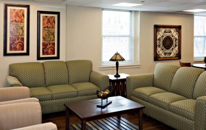 A cozy living room with two sofas, a wooden coffee table, and decorative wall art.