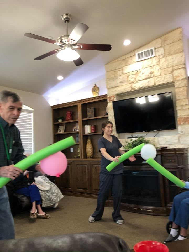 People enjoying a playful balloon game in the living room.