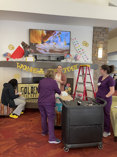 Staff members collaborating to prepare decorations for a women's event.