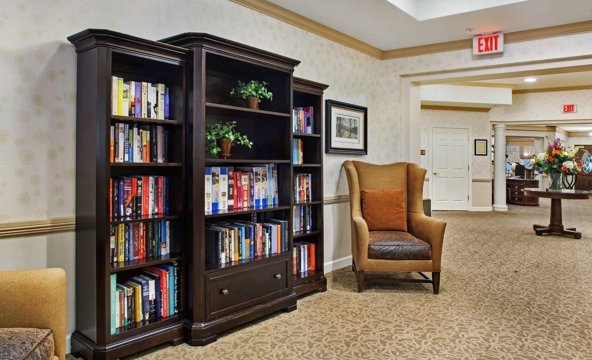A cozy library nook featuring a well-stocked bookshelf and a comfortable armchair.