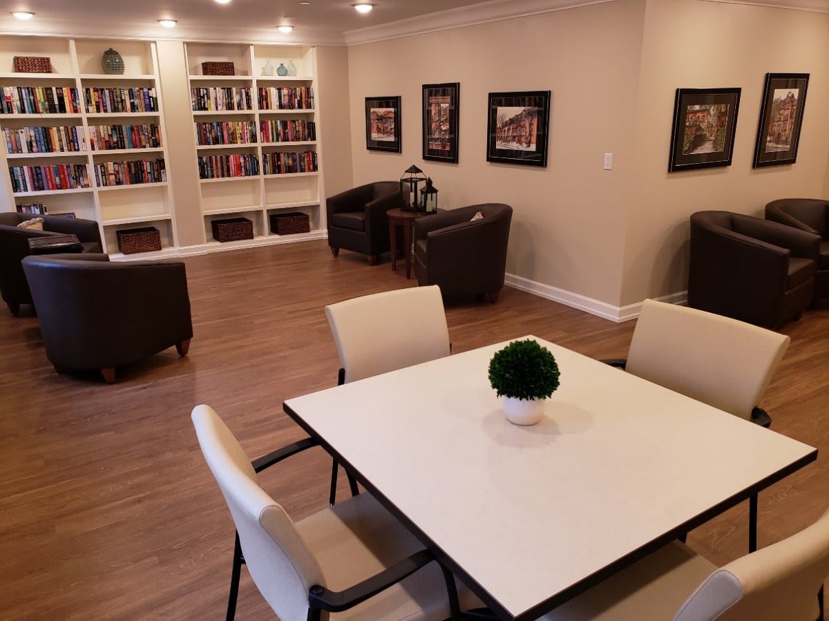 A modern reading room with bookshelves and seating area.