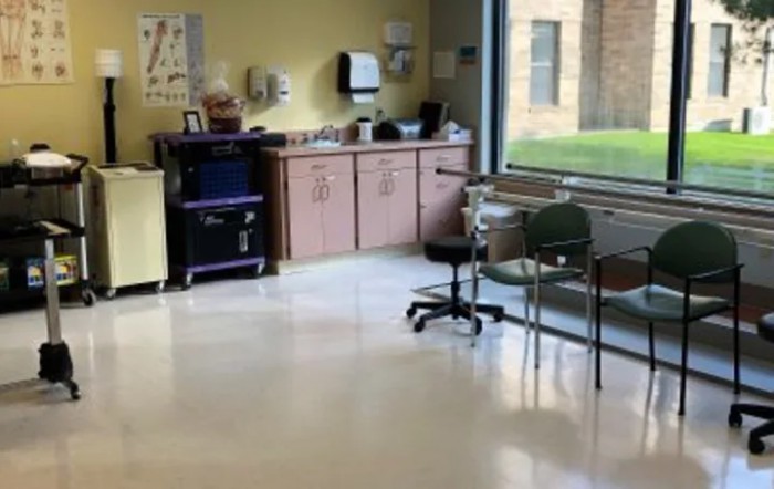 A hospital waiting room with chairs and medical equipment.