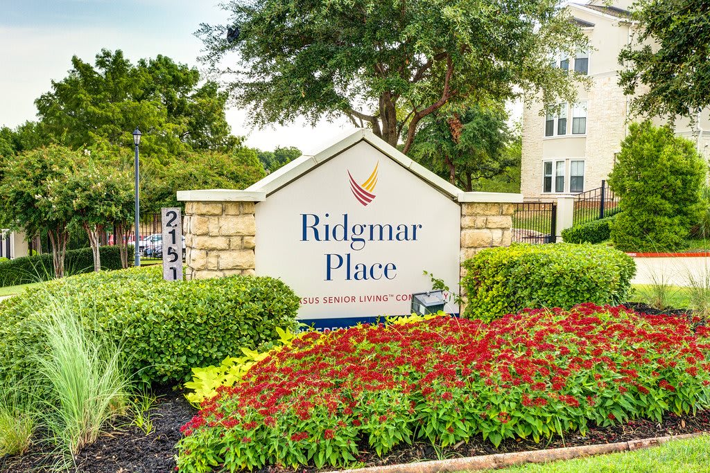 Entrance sign for Ridgmar Place surrounded by well-maintained landscaping and vibrant flowers.
