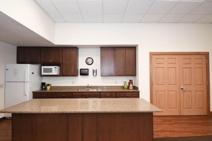 A modern kitchen with wooden cabinets and a spacious countertop.
