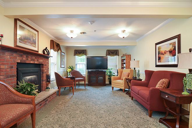 A cozy living room with a television and a fireplace, featuring comfortable seating and warm decor.