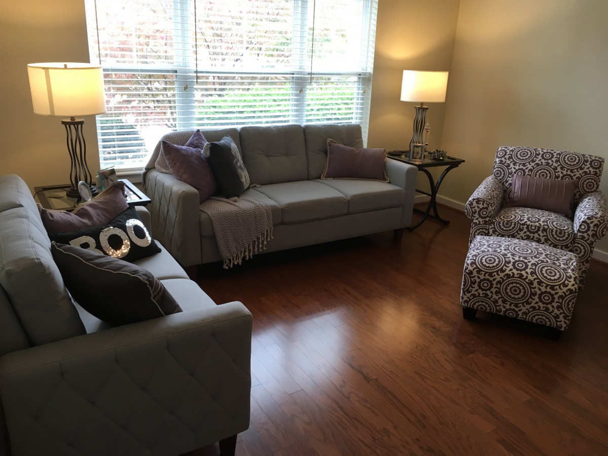A cozy living room with sofas, an armchair, and warm lighting.