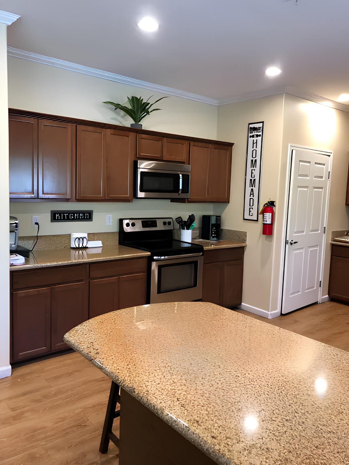A modern kitchen with wooden cabinets and a central island featuring stainless steel appliances.
