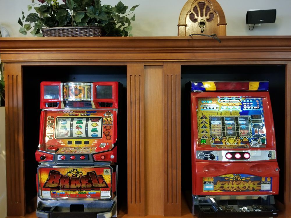 Two brightly colored slot machines placed side by side in an indoor setting.