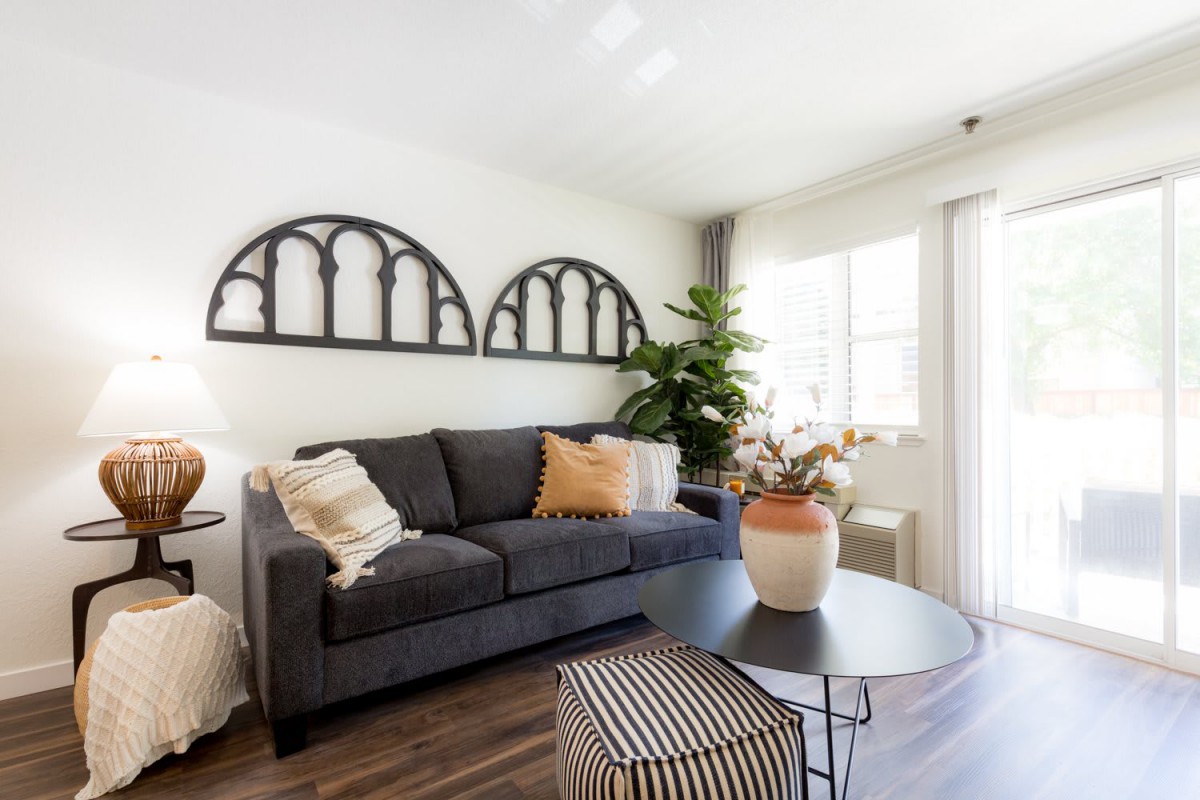 A modern living room with a dark gray sofa, decorative pillows, and stylish wall art.