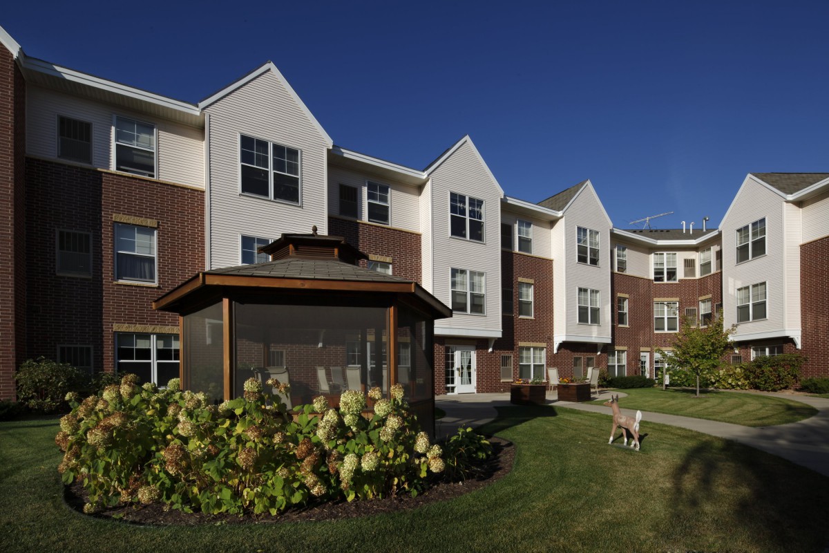 A modern apartment building with well-maintained landscaping on a clear day.