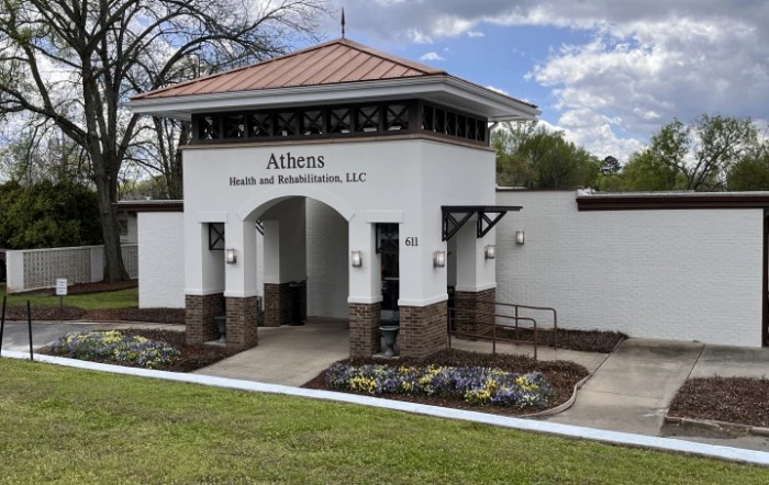 The entrance to a health and rehabilitation center, featuring landscaped flowers and architectural details.