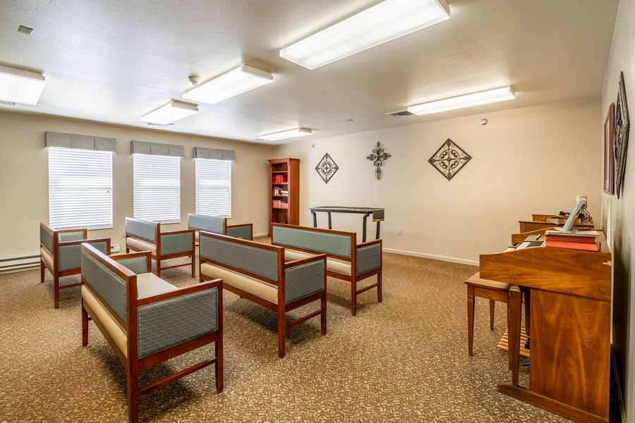 A small chapel interior with rows of benches and decorative wall elements.