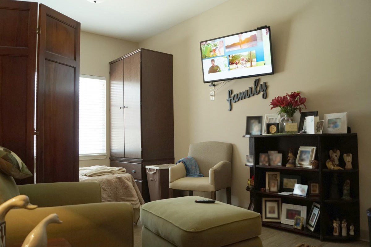 A cozy living room with a wall-mounted television and personalized decor.