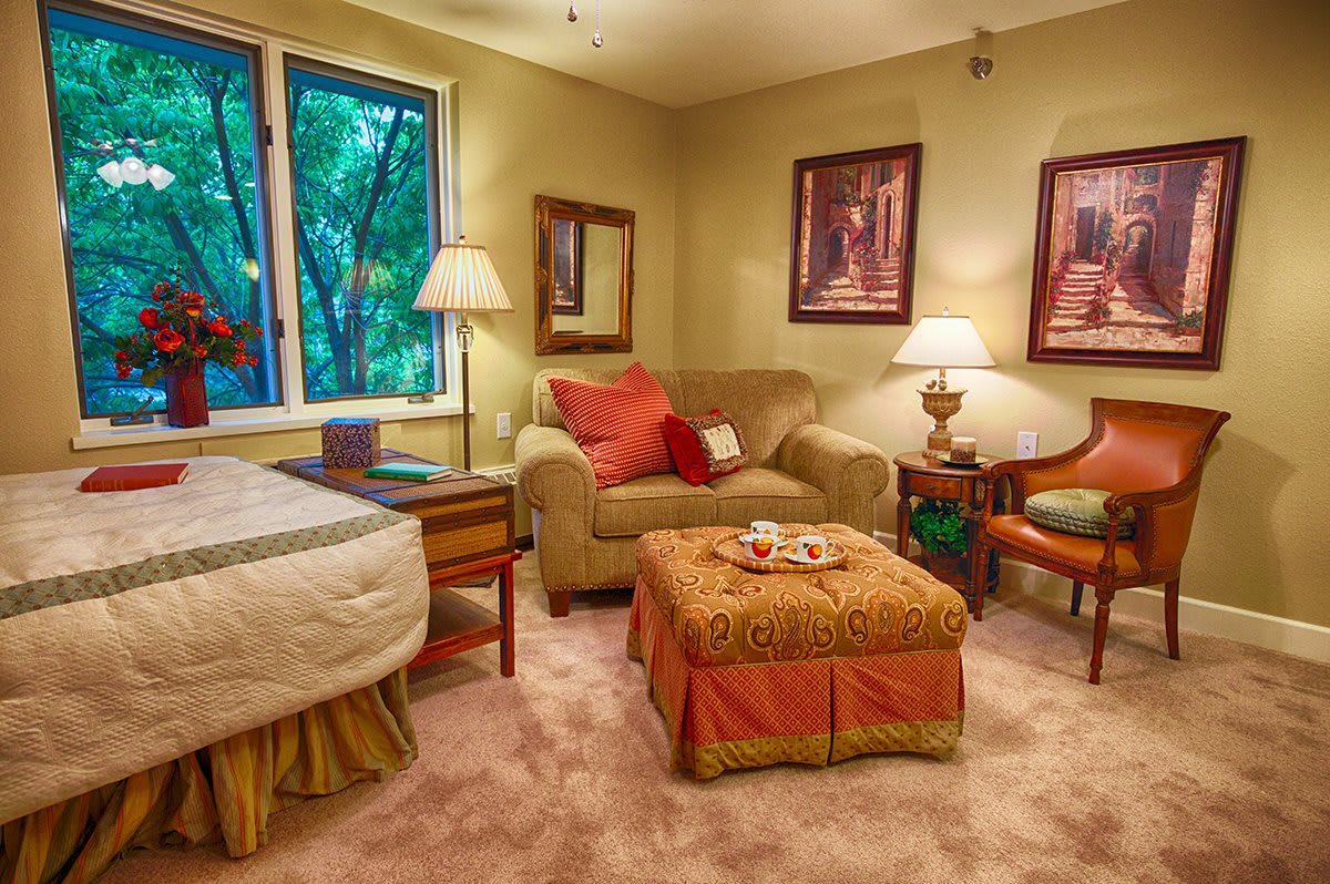 A cozy living room with warm lighting, a sofa, and decorative artwork on the walls.
