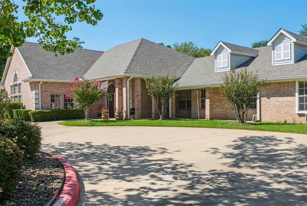 A suburban house with a wide driveway and well-maintained front yard.
