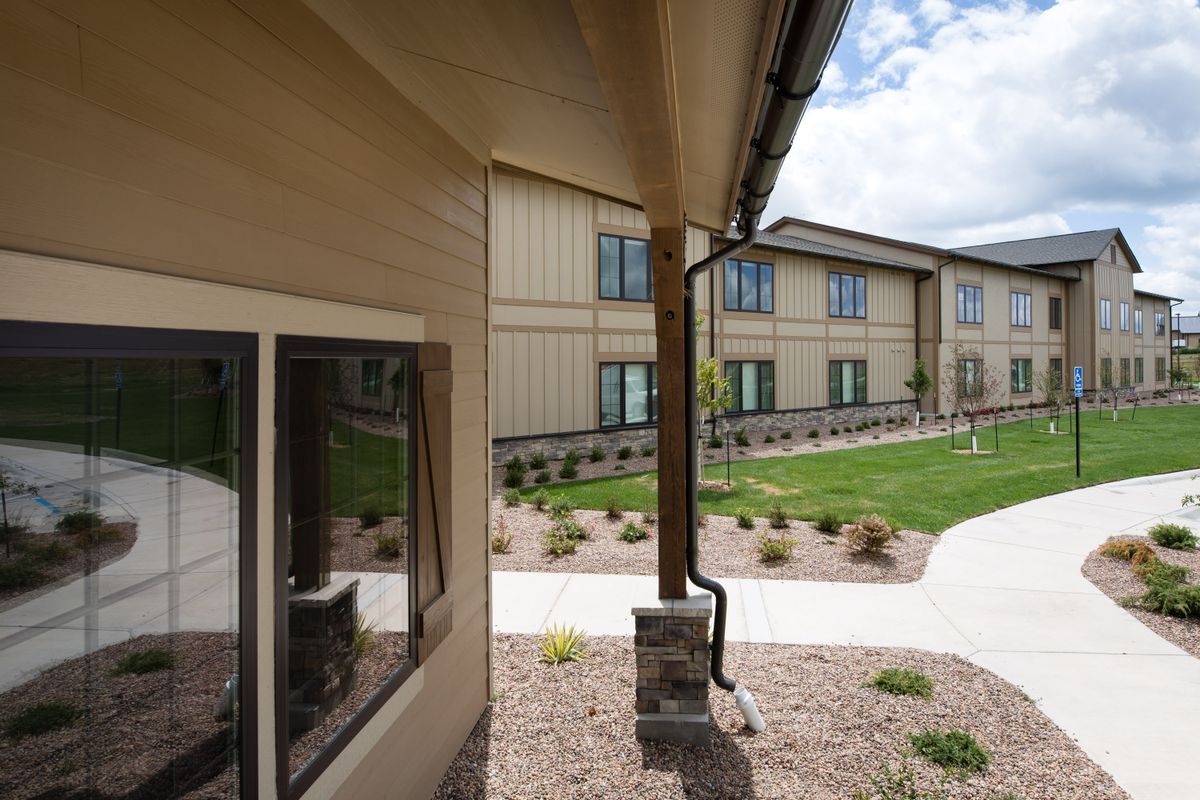 Exterior view of a two-story building with landscaped grounds and a pathway.