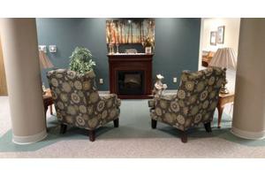 A cozy living room setup with two patterned chairs facing a fireplace.