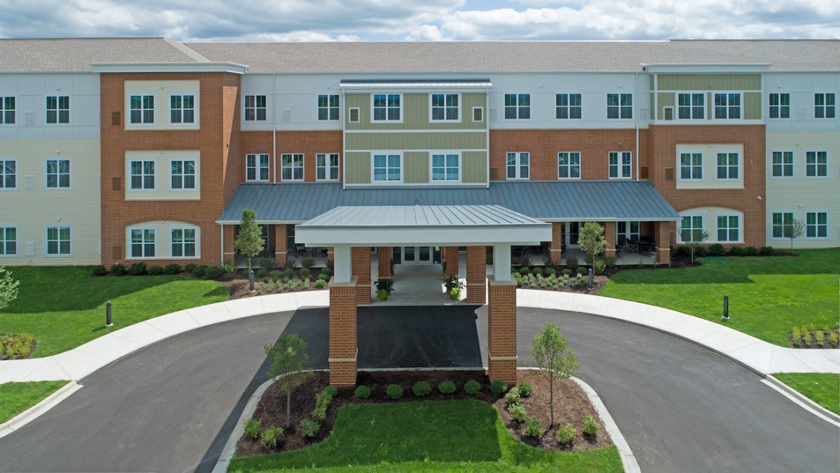 A front view of a modern residential building with landscaped grounds.