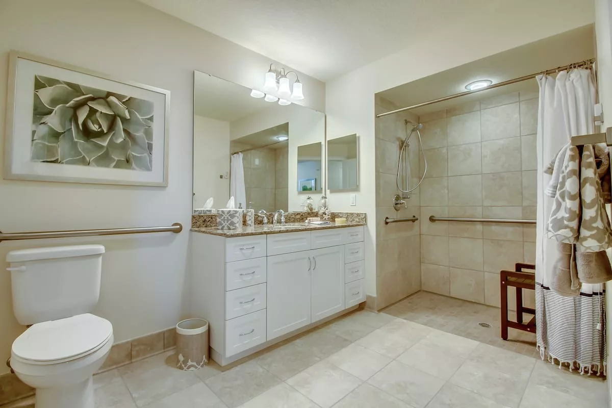 A spacious, modern bathroom featuring a large vanity with dual sinks and a walk-in shower.