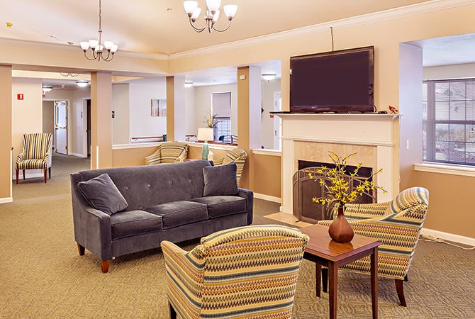 A cozy living room with comfortable seating, a fireplace, and a mounted television.