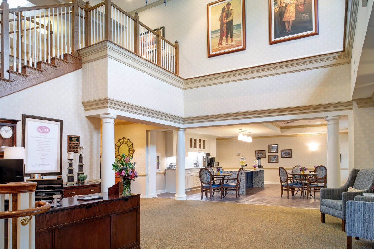 A spacious lobby area with a reception desk, seating arrangements, and artwork on the walls.