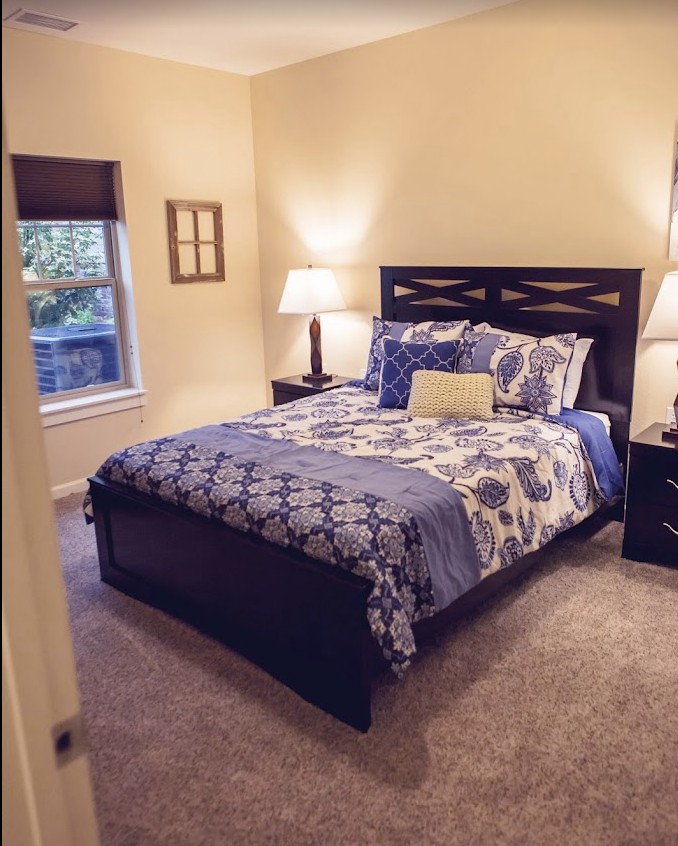 A cozy bedroom with a neatly made bed and warm lighting.