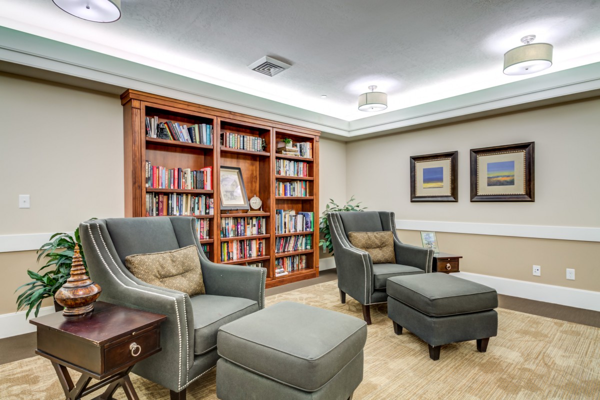 A cozy library with armchairs and bookshelves, providing a comfortable reading area.
