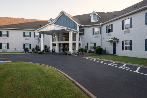 The inviting entrance of a hotel, featuring well-maintained landscaping and a welcoming facade.