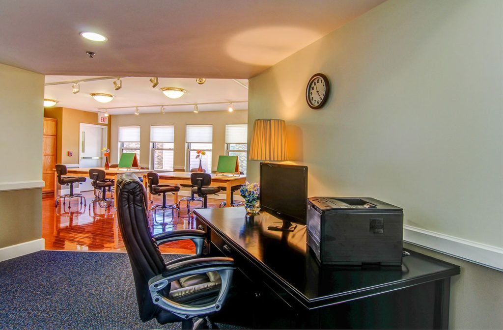 A modern office space with desks, chairs, and a computer setup.