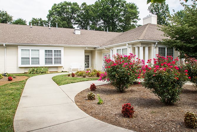 A picturesque house with a landscaped garden and a winding pathway.